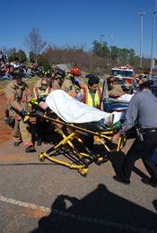 A DUI Reenactment showing a person being pushed on a stretcher by firefighters